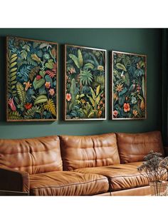 three paintings hang on the wall above a couch in a living room with green walls