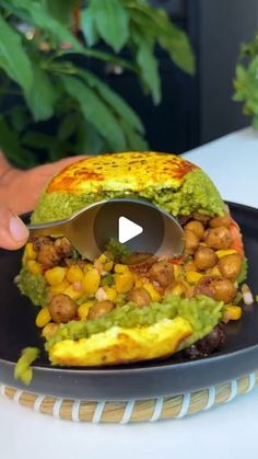 someone is cutting into a sandwich with guacamole and chickpeas on it