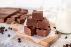 chocolate fudge brownies stacked on top of each other next to a glass of milk