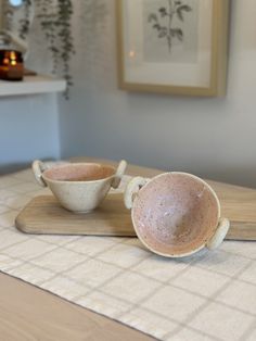 two cups sitting on top of a wooden table