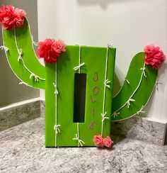 a green cactus shaped box with flowers on it