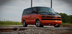 an orange van parked on the side of a road