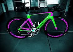 a bike is painted with neon colors in the dark room next to a bicycle rack