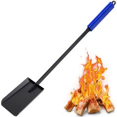 a spatula with flames on it next to an open fire pit and a shovel