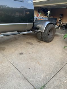 a large truck parked in front of a garage with it's flat tire on the ground