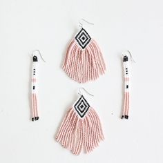 three pieces of beaded jewelry on a white surface with black and white beads hanging from them