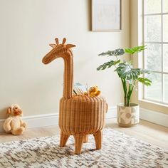 a wicker giraffe is sitting next to a potted plant and stuffed animals