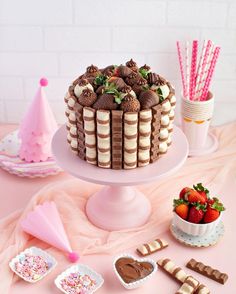 there is a cake on the table with strawberries and other desserts around it