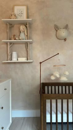 a baby's room with a crib and shelves on the wall