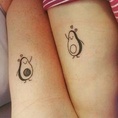 two small tattoos on the arms of women with penguin and heart shaped shapes in them