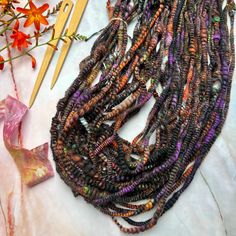 a bunch of beads sitting on top of a table next to a pair of scissors