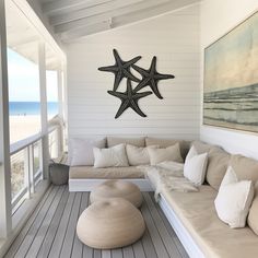 a living room filled with furniture and a starfish wall hanging over the couches