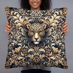 a woman holding up a decorative pillow with a leopard head on the front and sides