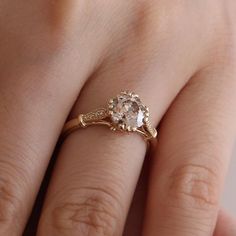 a woman's hand with a ring on it and a diamond in the middle