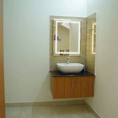 a bathroom with a sink, mirror and tiled flooring in front of the wall