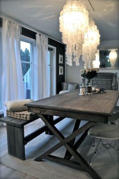 a dining room table with chairs and a chandelier hanging from it's ceiling