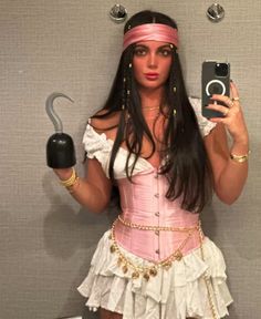 a woman in a pink corset holding up a cell phone