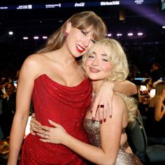 two women hugging each other in front of a crowd