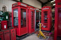 red telephone booths are lined up in a warehouse