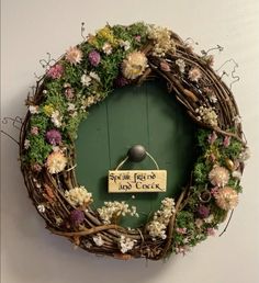 a green door with a sign on it that says little friends day clock surrounded by flowers