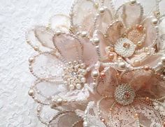 a close up of a flower made out of lace and pearls