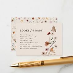 a pen sitting next to a card with the words books for baby written on it