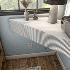 two vases sitting on top of a white shelf next to a lamp and window