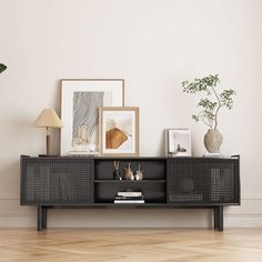 a living room with a large black cabinet and pictures on the wall above it,