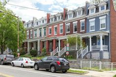 several cars parked on the street in front of row houses