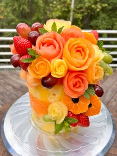 a cake decorated with fruit and flowers on a plate