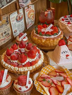 there are many desserts on the table with strawberries and other foods in baskets