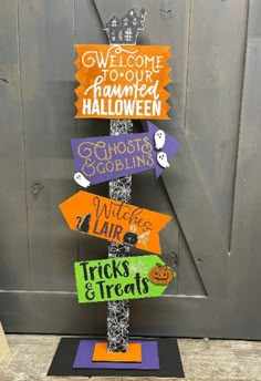 a wooden sign with halloween signs on it