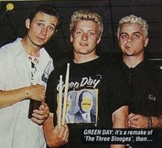 three men standing next to each other in front of a sign that says green day it's a remake of the three stooges, then