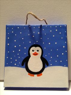 a penguin painted on a bag hanging from a wall