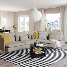 a living room filled with lots of furniture next to a large white ball hanging from the ceiling