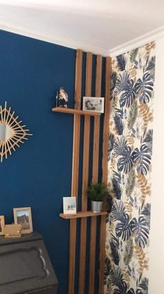 a living room with blue walls and wooden shelfs on the wall next to a piano