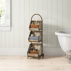 a bath tub sitting next to a wooden shelf with baskets on it's sides