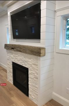 a flat screen tv mounted on the wall above a fireplace