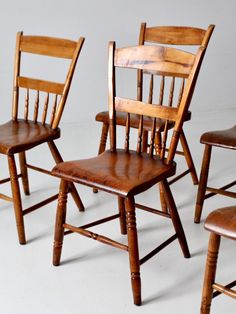 four wooden chairs sitting next to each other