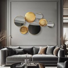 a living room with grey couches and gold mirrors on the wall above each sofa