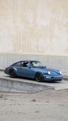 a blue sports car is parked on the curb