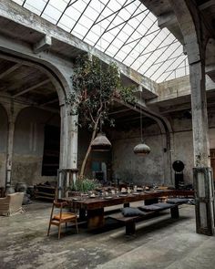 an old building with tables and benches in the center, surrounded by glass roofing