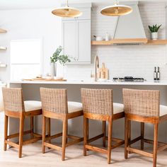 four chairs are lined up in front of the kitchen island