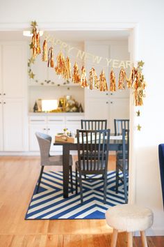 a table and chairs in a room with a happy new year banner hanging from the ceiling