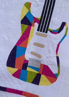 a quilted wall hanging with an electric guitar on it