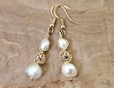 About this product: Our Freshwater Pearl Earrings are a dainty, opulent accessory that dangles lightly from your ears. Mother of pearl beads are used as the main centerpiece to this lovely set. It is then accented by 14k Filigree Beads and 925 Gold Earring wires. We've made these earrings with lightweight and allergen-friendly materials, so you can have your own beauty naturally accented without sacrificing any comfort. All materials listed are nickel-free and hypoallergenic. This product will c Elegant 14k Gold Filled Beaded Earrings For Gifts, Elegant 14k Gold Filled Beaded Earrings As Gift, Elegant Wire Wrapped Beaded Earrings, Elegant Hypoallergenic Teardrop Beaded Earrings, Elegant Hypoallergenic Beaded Drop Earrings, Elegant Gold Beaded Earrings Nickel-free, Elegant Wire Wrapped Beaded Earrings For Gift, Elegant Wire Wrapped Beaded Earrings As Gift, Adjustable Pearl Drop Beaded Earrings