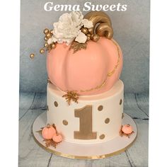 a pink and white cake with gold decorations on the top that says gema sweets