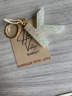 a keychain that has some kind of paper airplane on it with a tag attached to it