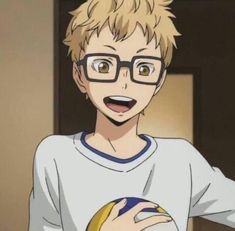 a boy with glasses holding a ball in his hand and smiling at the camera,