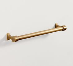 an old brass toilet roll holder on a white wall